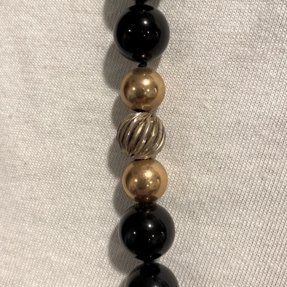 Beautiful black round beads with gold and silver inserts in the front